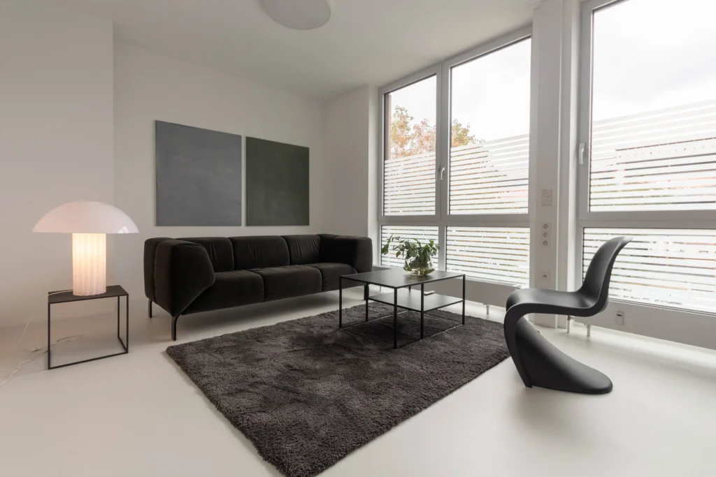 Heller Therapieraum des TZB Göppingen mit Sofa, Panton-Stuhl und bodentiefen Fenstern